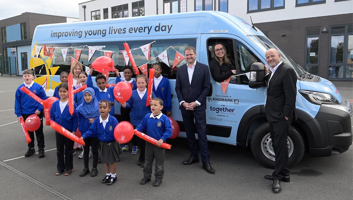 Group beside a Sunshine Coach at a school.